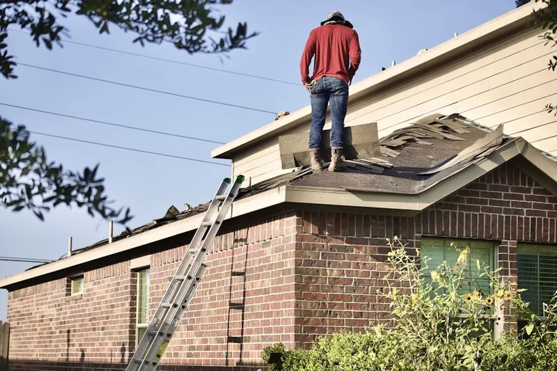 Professional roofer working on a residential roof in Laurinburg